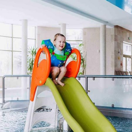 Dziewczynka na zjeżdżalni w basenie w Hotelu Białowieski w Białowieży